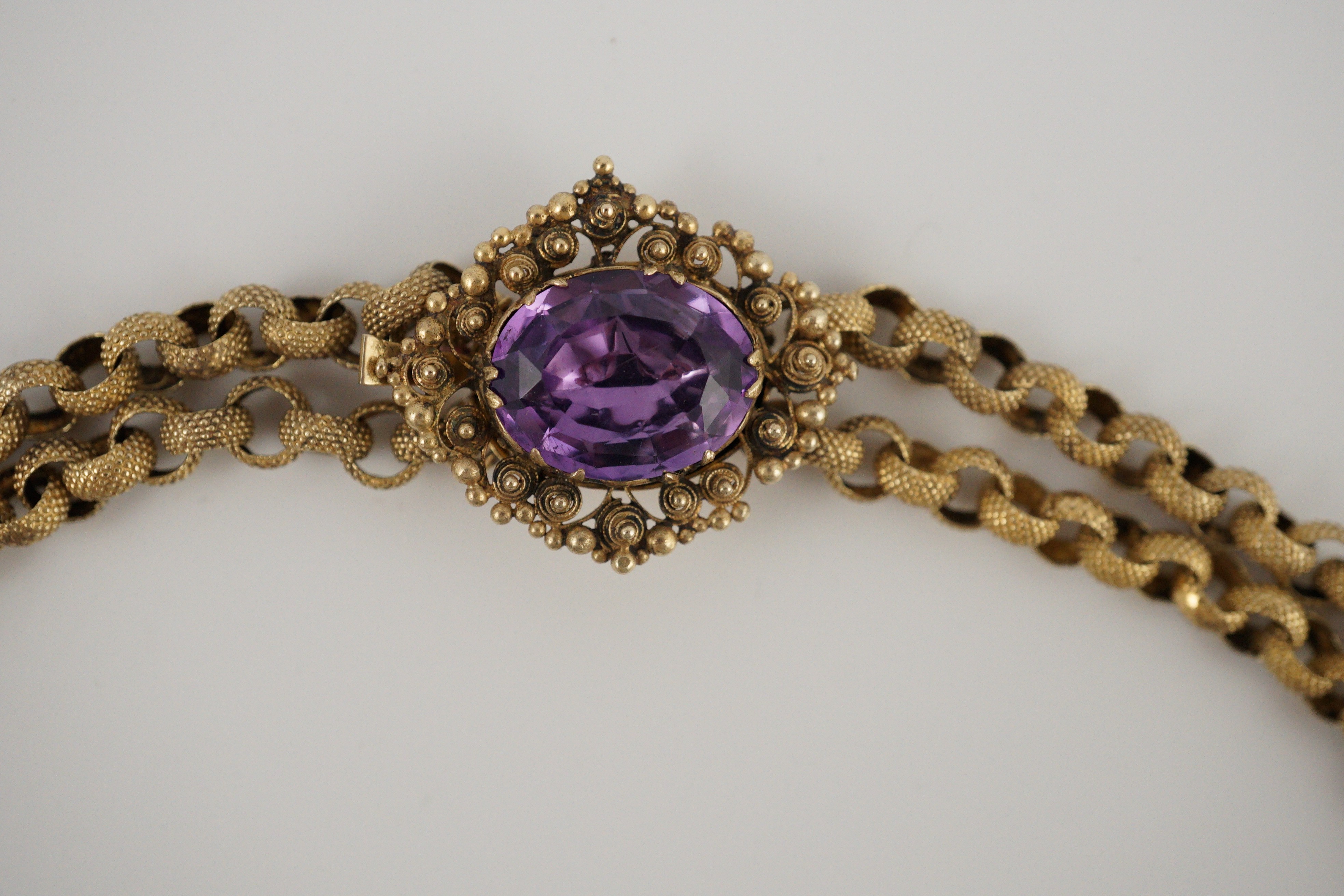 An early 19th century gold and eleven stone oval cut amethyst set pendant necklace and a similar cross pendant (repair)